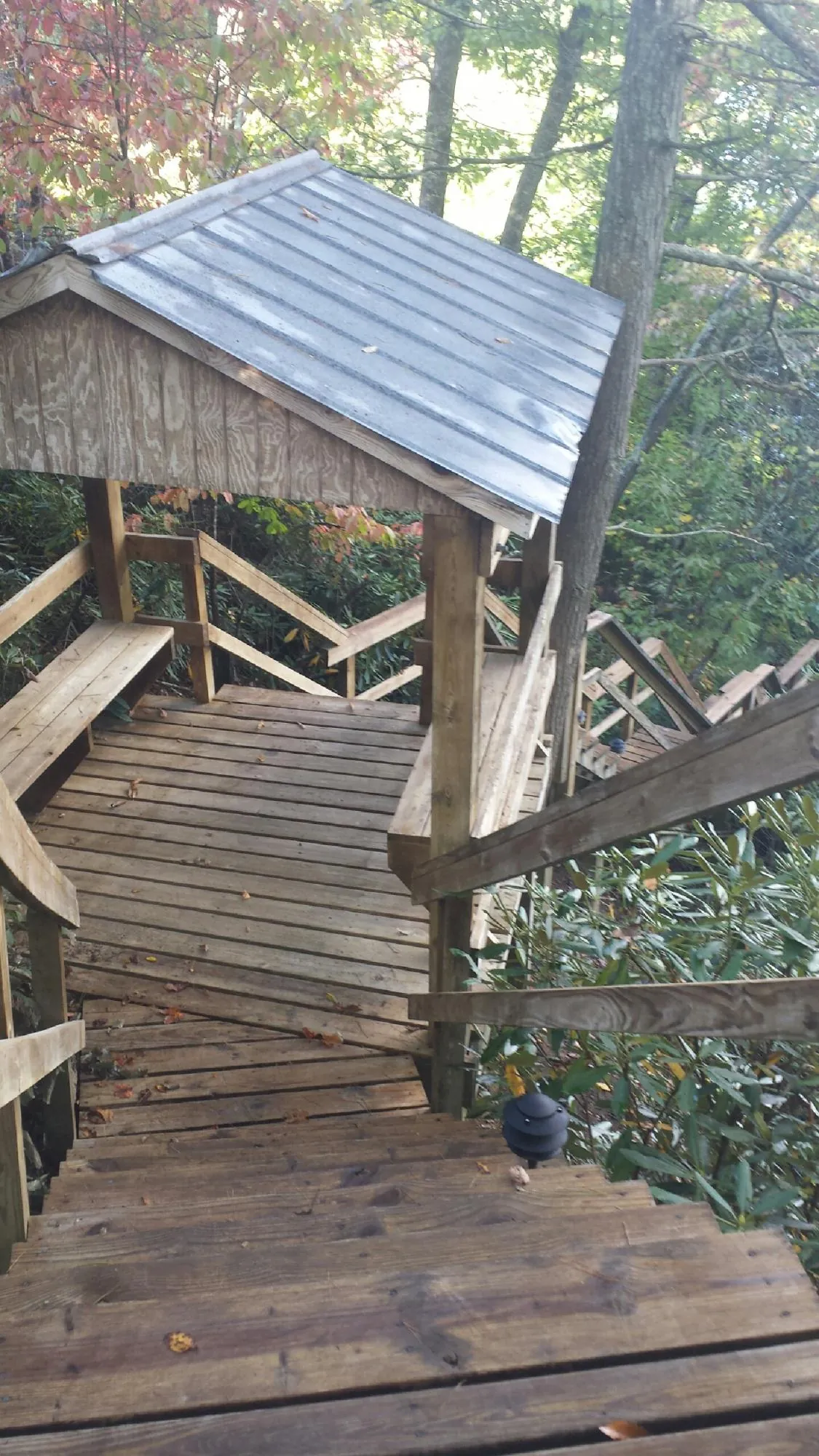Metal roofed shelter over wooden steps on a wooded walkway — Skylight Repair & Installation work by our crew in Two Dot