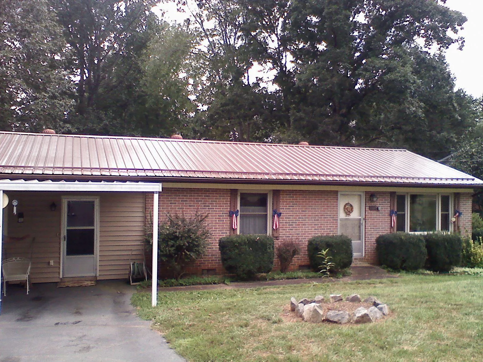 Bronze metal roof and carport on a brick ranch home — Roof Repair work by our crew in Two Dot